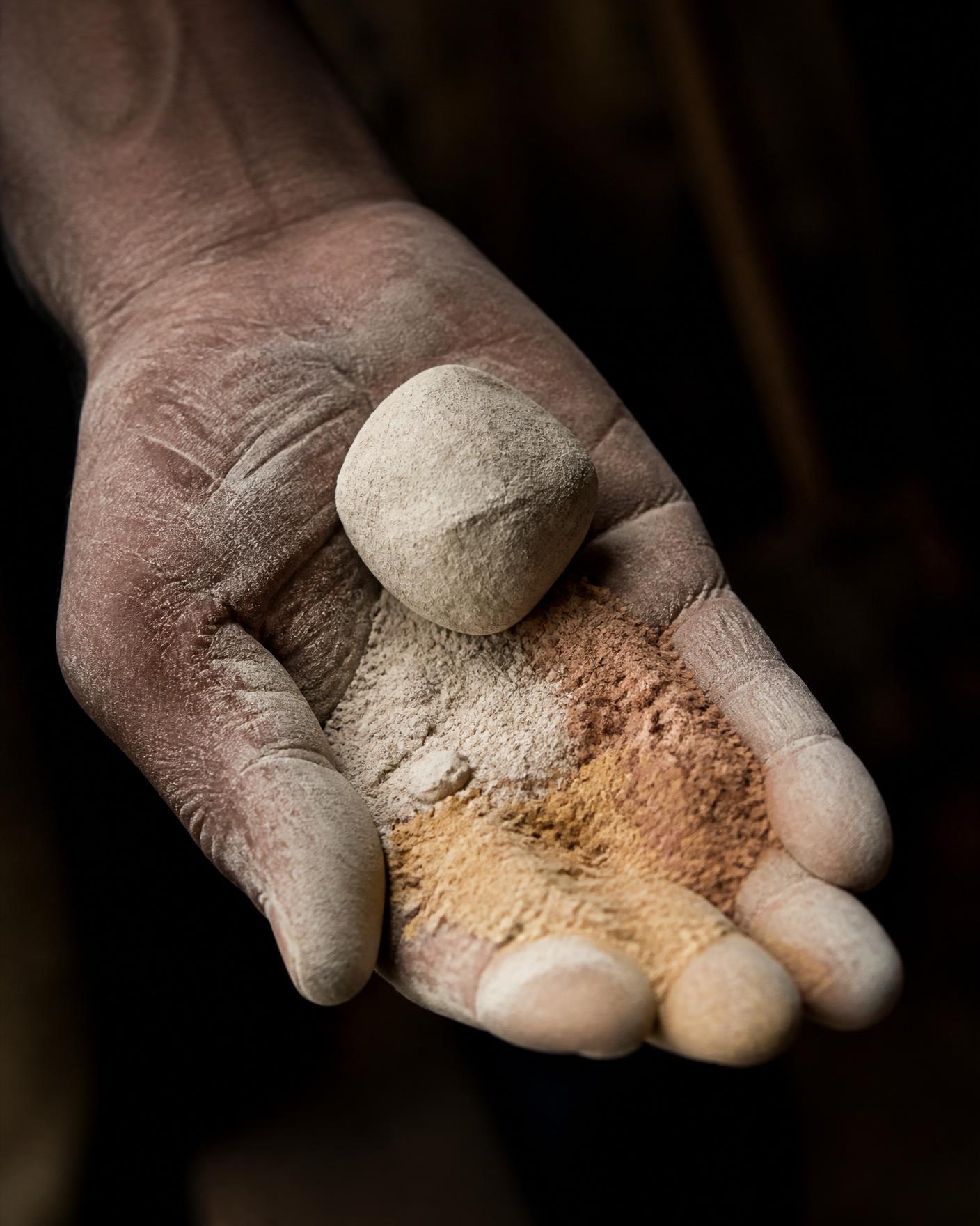 Artisan's hand holding raw lime and marble dust pigments